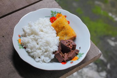 Geleneksel lezzetli gudeg pilavı ve yanında da cam tabakta servis edilen mayonez dolu sosis.