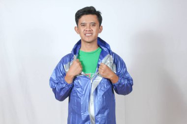 Asyalı adam ceketini çıkarır ve yağmur fermuarı çeker. 