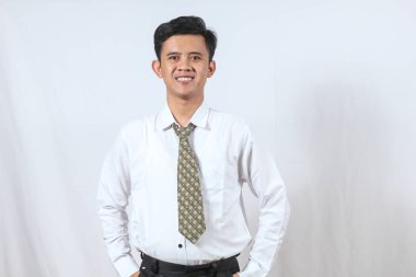 Beyaz arka planda geniş bir izole edilmiş, gülümseyen, kravatlı bir ofis adamı portresi.