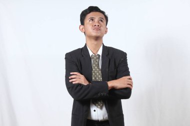 Asyalı iş adamı kollarını kavuşturdu. Çözüm bulmak için kafa yoruyor. İzole edilmiş beyaz bir zemin.