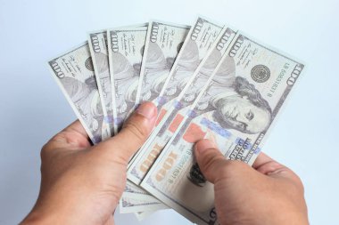 Beyaz arka planda 100 dolarlık banknot tutan bir adam. Finans konsepti.