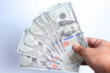 Beyaz arka planda 100 dolarlık banknot tutan bir adam. Finans konsepti.