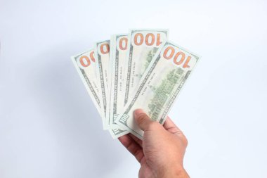 Beyaz arka planda 100 dolarlık banknot tutan bir adam. Finans konsepti.