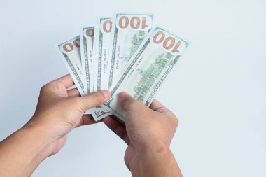 Beyaz arka planda 100 dolarlık banknot tutan bir adam. Finans konsepti.