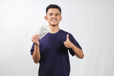 Asyalı bir adamın portresi. Donanma tişörtü giyiyor. Çok para taşıyor.