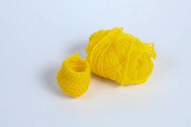 Sarı yün iplik ve işlemeli başparmak eldiveni beyaz arkaplanda izole edilmiş.