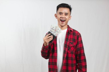 Beyaz arka planda izole edilmiş dolar dolu cüzdan taşıyan Asyalı bir adam.