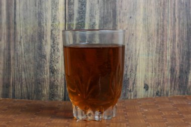 Bir bardak sıcak çay sabah içmeye hazır ahşap bir masada.