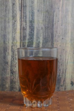 Bir bardak sıcak çay sabah içmeye hazır ahşap bir masada.