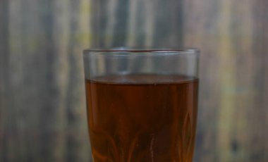 Eski ahşap arka planda bir bardak taze tatlı çay.