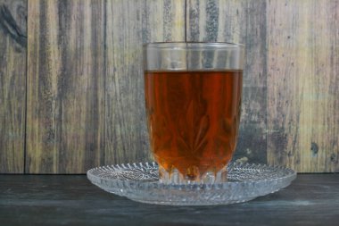 Eski ahşap arka planda bir bardak taze tatlı çay.