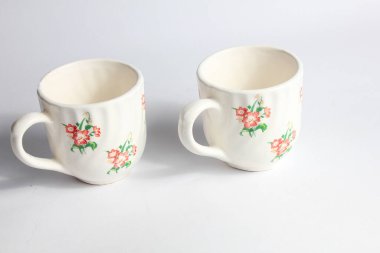 Çiçek desenli beyaz seramik bardak ev arka planında izole edilmiş, klasik ev mobilyaları.