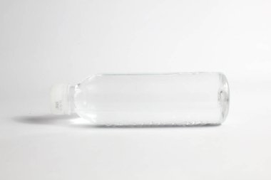 Beyaz arka planda izole edilmiş şeffaf plastik şişedeki maden suyu.