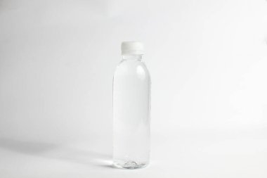 Beyaz arka planda izole edilmiş şeffaf plastik şişedeki maden suyu.