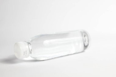 Beyaz arka planda izole edilmiş şeffaf plastik şişedeki maden suyu.