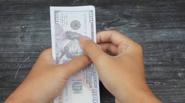 Adam siyah masada dolar sayıyor.