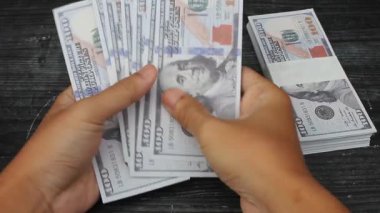 Adam siyah masada dolar sayıyor.