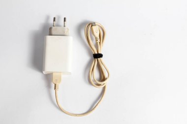 Kullanılan cep telefonu şarjı beyaz arkaplanda izole edildi