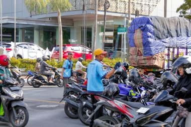 Endonezya, Solo - Haziran 12025: Sokak park görevlileri park motosikletleri ve müşterilerin motosikletleri üzerinde çalışıyorlar