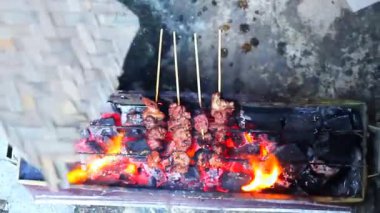 Baharatlı çiğ keçi yahnisi pişene kadar ızgarada kızartılır.