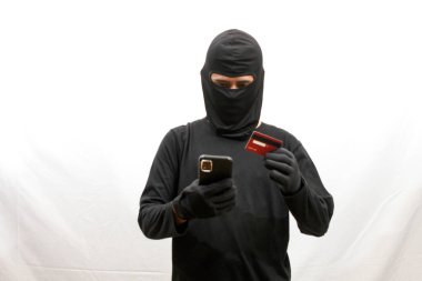 Hackerlar çalıntı kredi kartı ve telefonları ellerinde tutuyor. Güvenliği aşıp tüm parayı çekmeye çalışıyorlar.