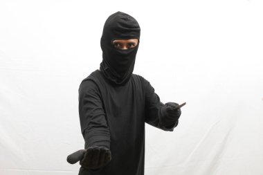 Keskin bir silah tutan kar maskeli bir hırsız, kurbanı eşyaları teslim etmekle tehdit ediyor.