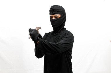 Hırsız çekiç ve dövüş sanatlarını kullanarak içeri girmeye çalışıyor. Sert vuruyor, beyaz arka planda soyutlanıyor.