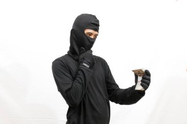 Hırsızın elinde yığınla para var. Kafası karışmış, beyaz arka planda soyutlanmış.