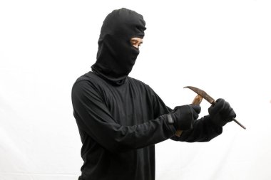 Hırsız çekiç ve dövüş sanatlarını kullanarak içeri girmeye çalışıyor. Sert vuruyor, beyaz arka planda soyutlanıyor.