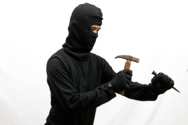 Hırsız çekiç ve dövüş sanatlarını kullanarak içeri girmeye çalışıyor. Sert vuruyor, beyaz arka planda soyutlanıyor.