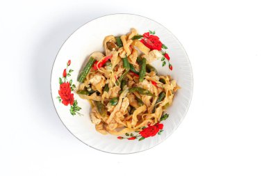 Baharatlı mantar kızartması tofu ve su ıspanağı ile birlikte beyaz arka planda izole edilmiş bir tabakta servis edilir.