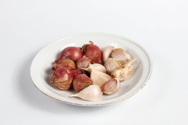 Beyaz arkaplanda izole edilmiş bir tabakta kırmızı ve beyaz soğan