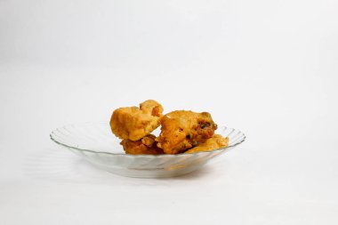 Sebze ve kızarmış tempeh ile doldurulmuş kızarmış tofu şeffaf cam bir tabakta servis edilir, beyaz arka planda izole edilir.