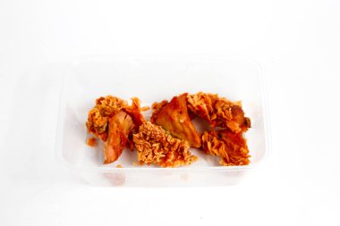 Beyaz arka planda izole edilmiş saydam mika kabında saklanmış çıtır Kentucky tavuğu.