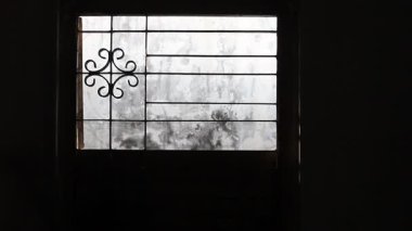 Mahkumların açık pencereli ve demir parmaklıklı tutulduğu karanlık oda.