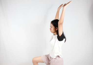 Genç Asyalı kadın yoga egzersizi yapıyor. Beyaz arka planda tamamen izole edilmiş konsantrasyonla.