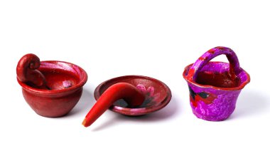 Minyatür kil tabaklar ve bir sepetin yer aldığı el boyaması ve parlak renkli bir yaşam düzeni..