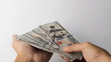 Bir yığın Amerikan dolarının el ele tutuşması ve sunulması zenginliği, refahı, yatırımı ve finansal fırsatları sembolize eder..