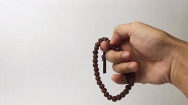 El ele tutuşan dua boncukları beyaz arkaplanda yalıtılmış dhikr etkinliği yapıyor