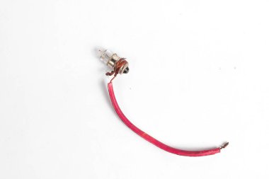 Pilot lamba, kabloya sarılı küçük bir lamba, saat pili ya da akümülatörle aydınlatılmış, beyaz arka planda izole edilmiş. Genellikle motosiklet ışıklarında kullanılır..