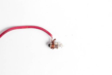 Pilot lamba, kabloya sarılı küçük bir lamba, saat pili ya da akümülatörle aydınlatılmış, beyaz arka planda izole edilmiş. Genellikle motosiklet ışıklarında kullanılır..