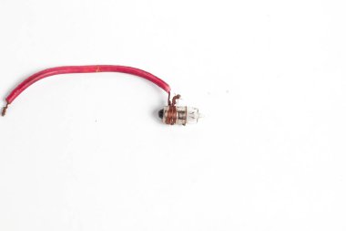 Pilot lamba, kabloya sarılı küçük bir lamba, saat pili ya da akümülatörle aydınlatılmış, beyaz arka planda izole edilmiş. Genellikle motosiklet ışıklarında kullanılır..