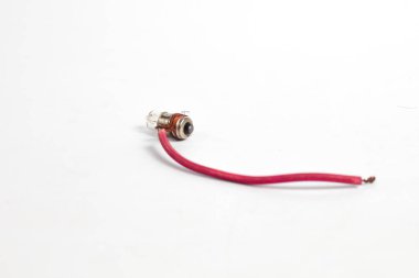 Pilot lamba, kabloya sarılı küçük bir lamba, saat pili ya da akümülatörle aydınlatılmış, beyaz arka planda izole edilmiş. Genellikle motosiklet ışıklarında kullanılır..