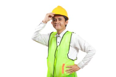 Profesyonel bir stüdyo ortamında sarı şapka ve güvenlik yeleği giyen gülümseyen inşaat işçisi görülüyor.