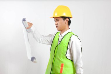 Asyalı inşaat işçisi elinde projeyle beyaz arka planda ciddi şekilde izole edilmiş görünüyor. Konsept mühendisi ve iş adamı. Başarı.