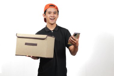 Kurye, harita uygulamasını açan akıllı telefonu tutarken müşterinin paket kutusunu taşır.