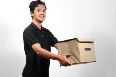 Siyah polo tişört giyen gülen bir teslimatçı elinde bir paket kutusu ile müşterinin gideceği adrese teslim ediyor. Servis kavramı