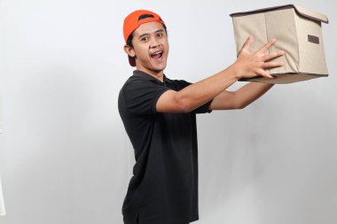 Kutu taşıyan arkadaş canlısı teslimatçı kapına gülümseyerek hızlı bir nakliyat ve kusursuz bir servis sunuyor.