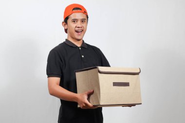 Kutu taşıyan arkadaş canlısı teslimatçı kapına gülümseyerek hızlı bir nakliyat ve kusursuz bir servis sunuyor.