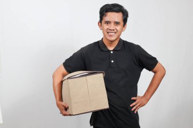 Kutu taşıyan arkadaş canlısı teslimatçı kapına gülümseyerek hızlı bir nakliyat ve kusursuz bir servis sunuyor.